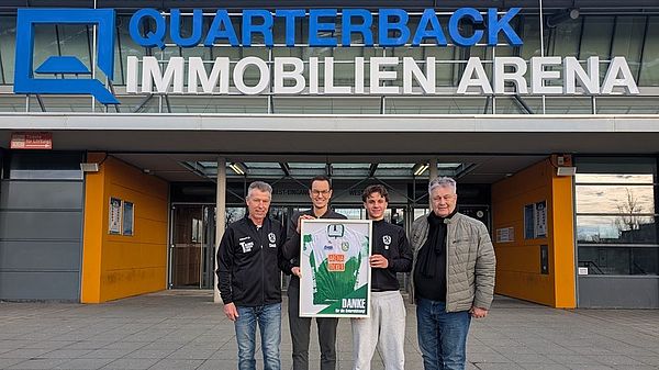 Auf dem Foto stehen vor der QUARTERBACK Immobilien ARENA (von links nach rechts): Roland Hempel (Abteilungsleiter Radsport beim SC DHfK), Philipp Franke (Geschäftsführer der ZSL Betreibergesellschaft mbH), Nachwuchs-Radsportler Oskar Doberschütz und SC DHfK-Präsident Bernd Merbitz. 