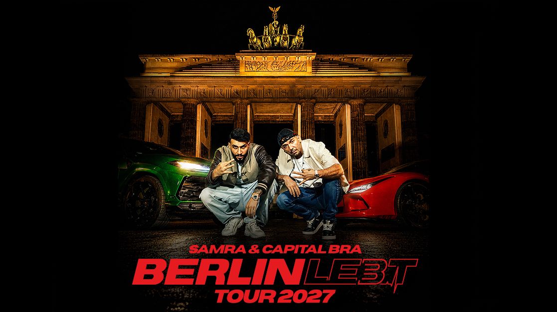 Auf dem Pressebild der Tour von Capital Bra und Samra knien die beiden Rapper auf der Straße vor dem Brandenburger Tor. Hinter ihnen stehen zwei Sportwagen. Es ist ein Nacht-Bild, das Brandenburger Tor ist beleuchtet. Der Asphaltboden wirkt nass. 