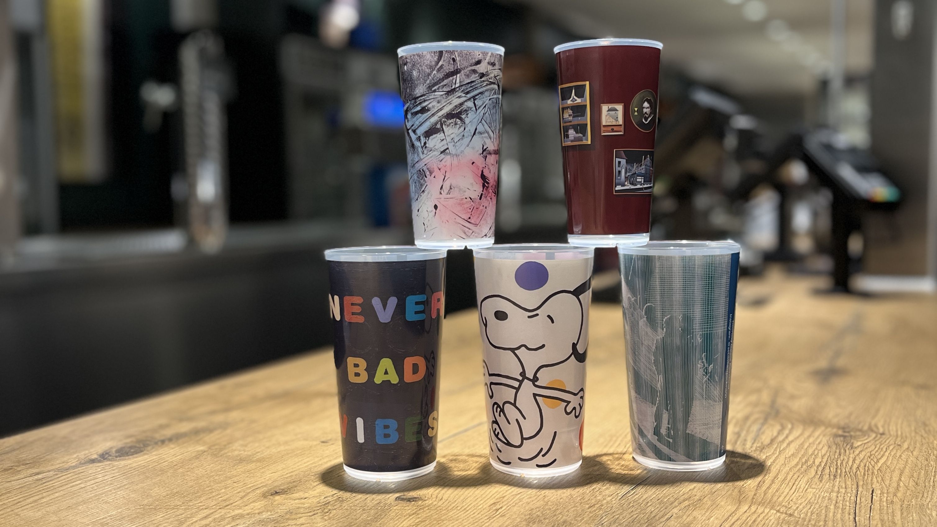 Fünf aufgestapelte Mehrwegbecher auf dem Tresen eines Gastrostands. 