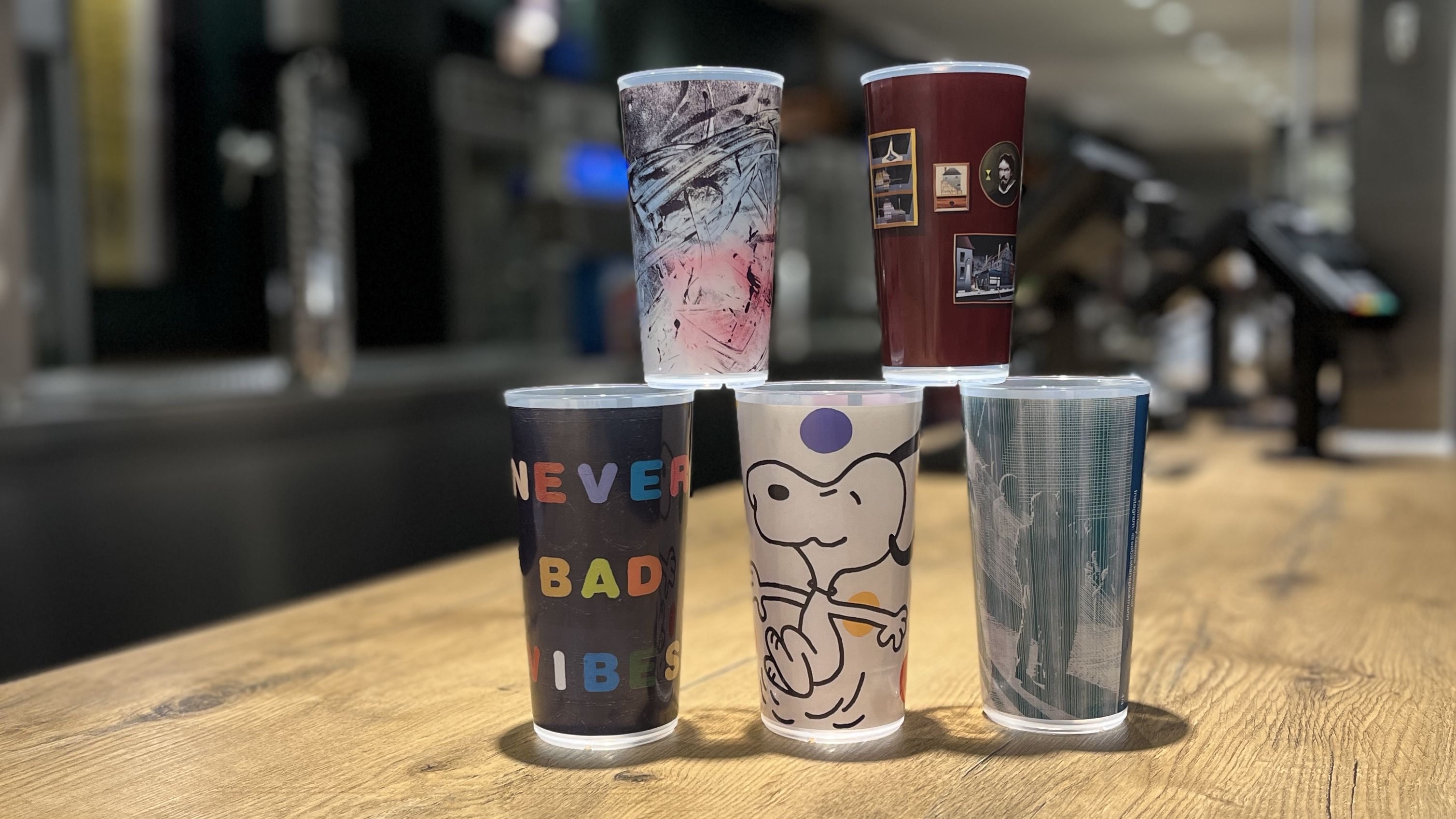 Fünf aufgestapelte Mehrwegbecher auf dem Tresen eines Gastrostands. 