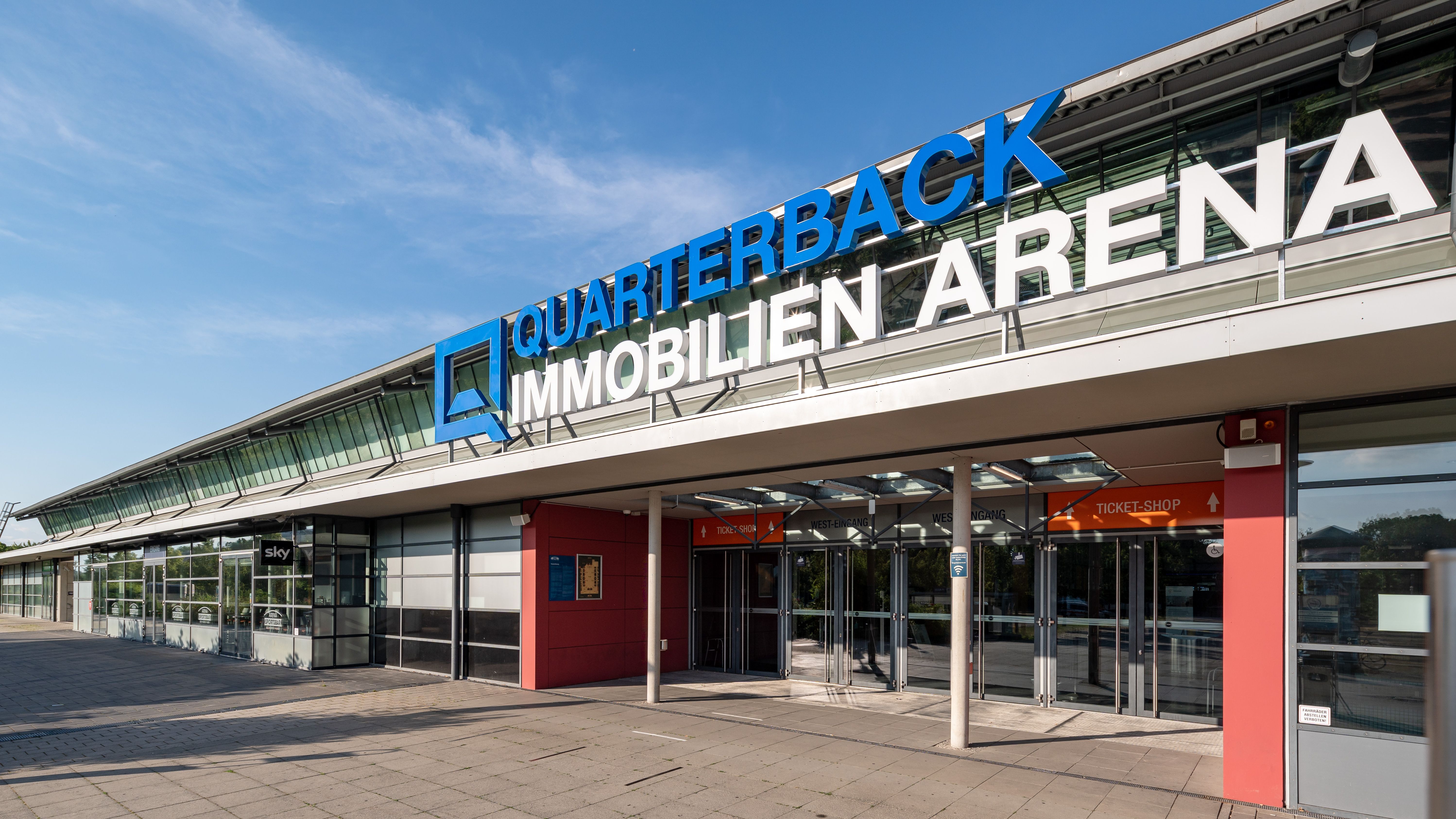 Schräge Außenaufnahme des Schriftzugs der QUARTERBACK Immobilien ARENA. 