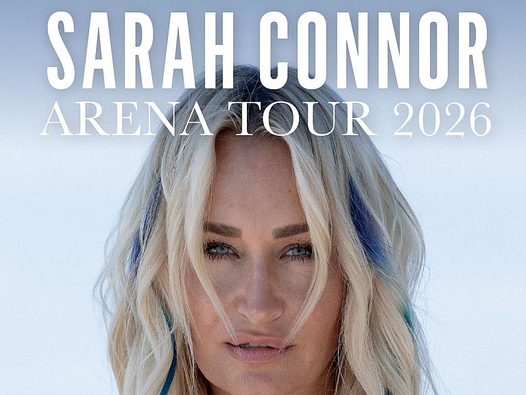 Sarah Connor hat zwei blaue Strähnen im Haar und trägt ein Jeansoberteil.