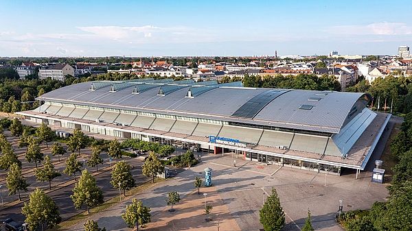 Luftaufnahme der QUARTERBACK Immobilien ARENA mit Blick auf Parkplatz und Stadt.