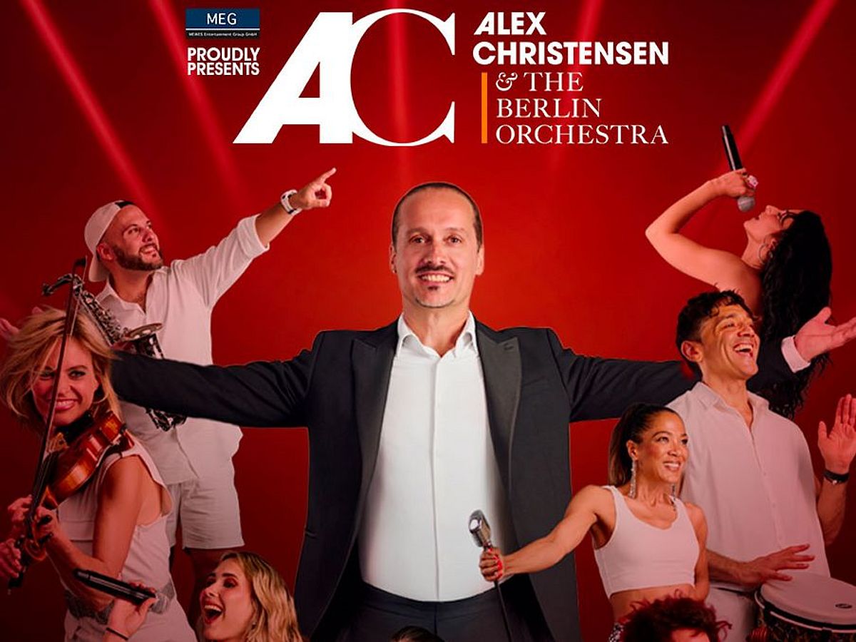 Band mit Alex Christensen trägt weiße Kleidung, einige haben ihr Instrumente in der Hand, andere strecken eine Hand nach oben.