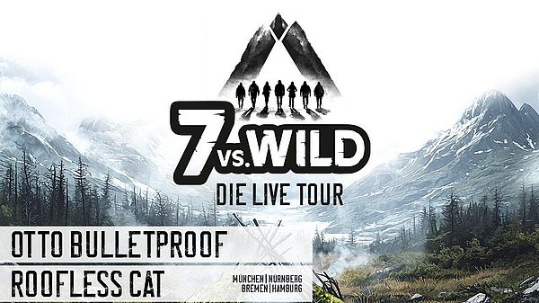 Im Vordergrund ist eine Feuerstelle mit einer selbstgebauten Holthütte zu sehen. Im Hintergrund sind Berge, die schneebedeckt sind. 