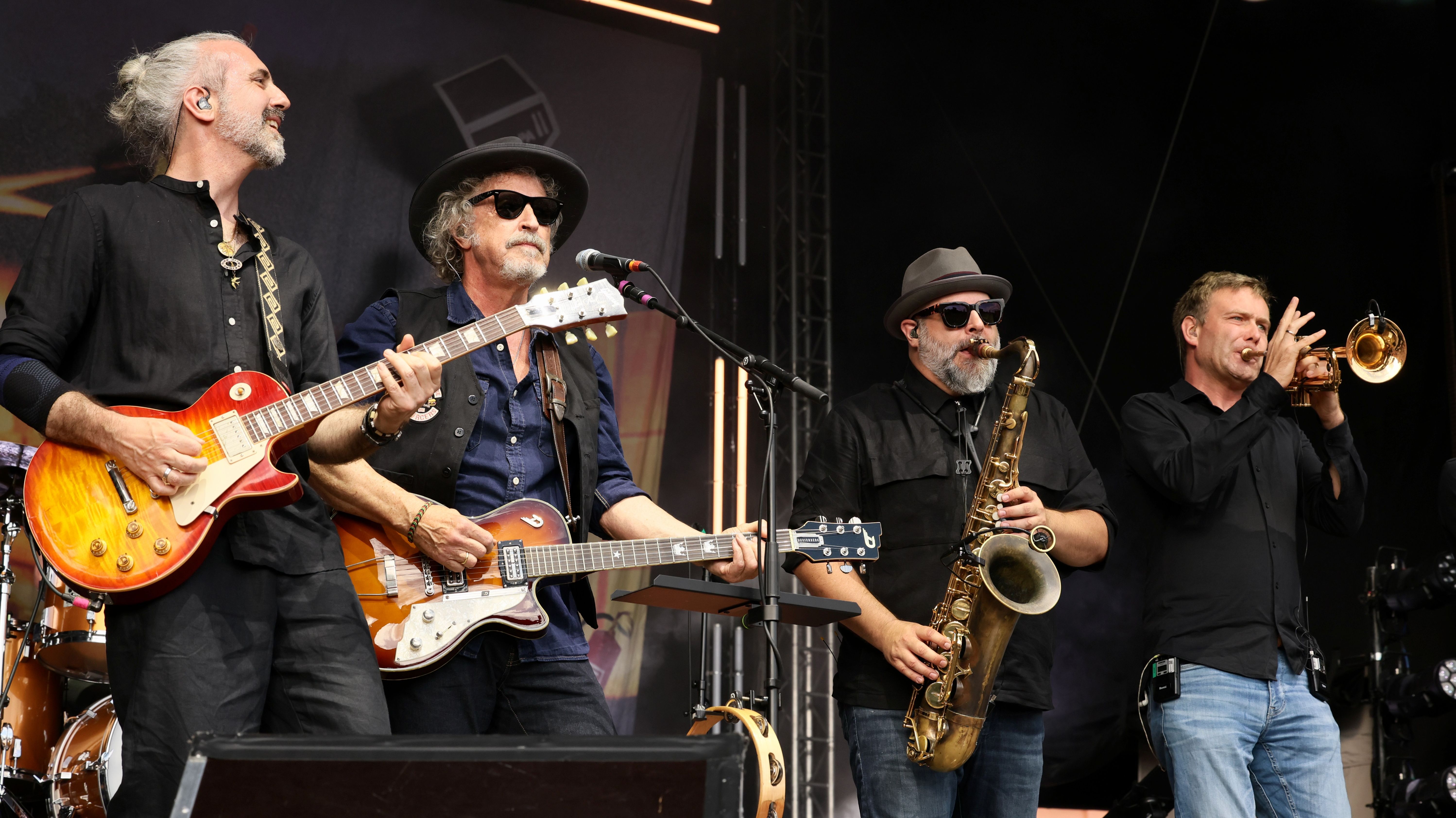 Ein Live-Foto der Band BAP auf einer Bühne mit ihren Instrumenten. 