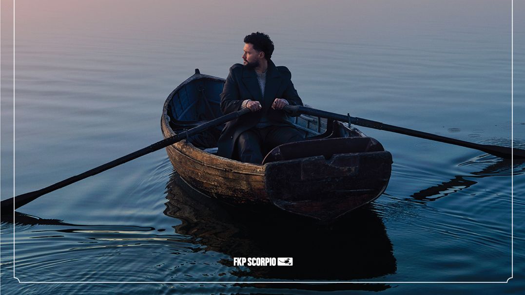 Tourplakat von Calum Scott mit den Tourdaten der Avenoir Tour. Das Plakat ist ist in rosé und blau-Tönen gehalten. Im unteren Bereich sieht man Calum Scott in einem Ruderboot sitzen. 
