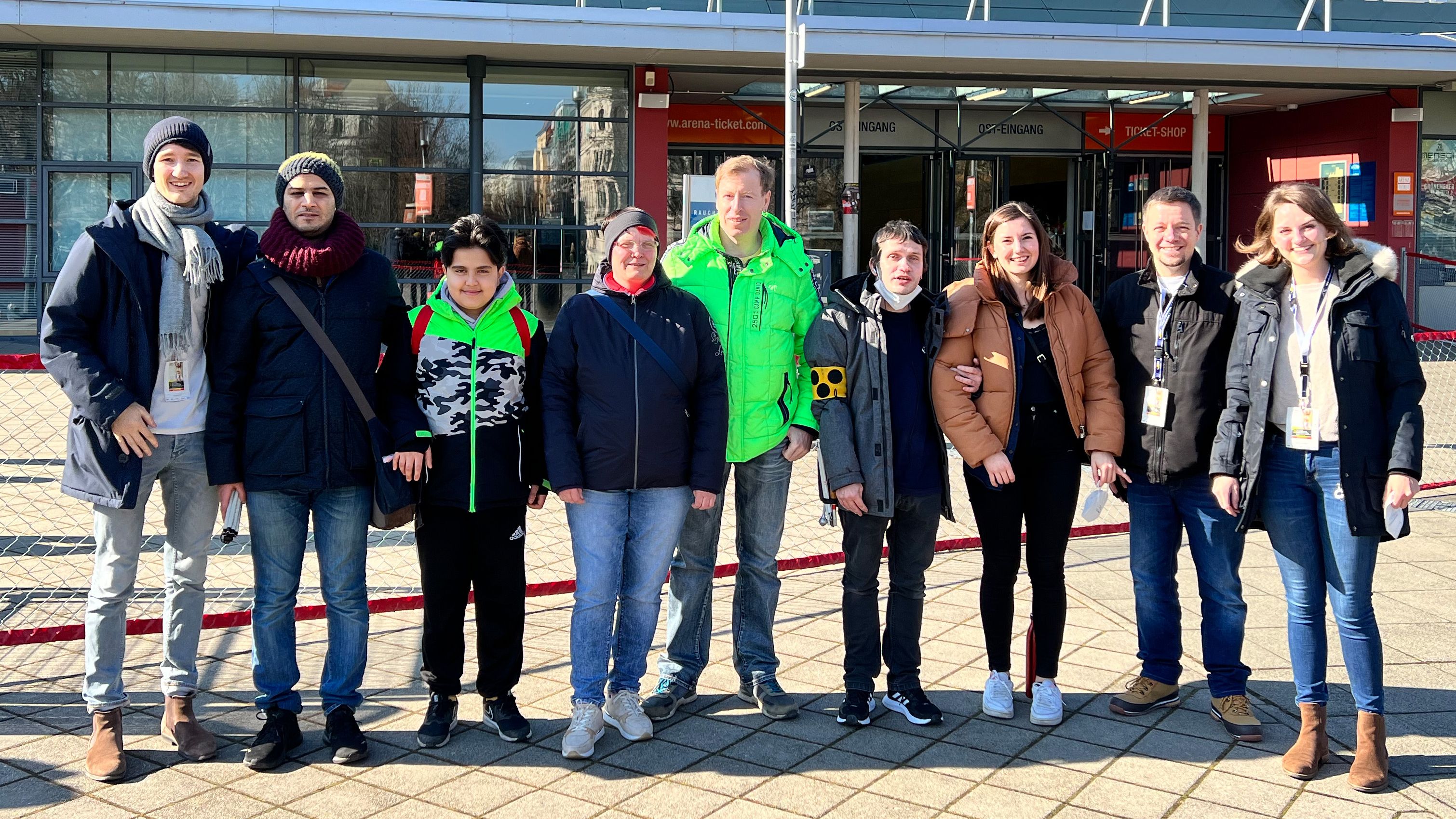 Eine Gruppe steht vor der QUARTERBACK Immobilien ARENA. 