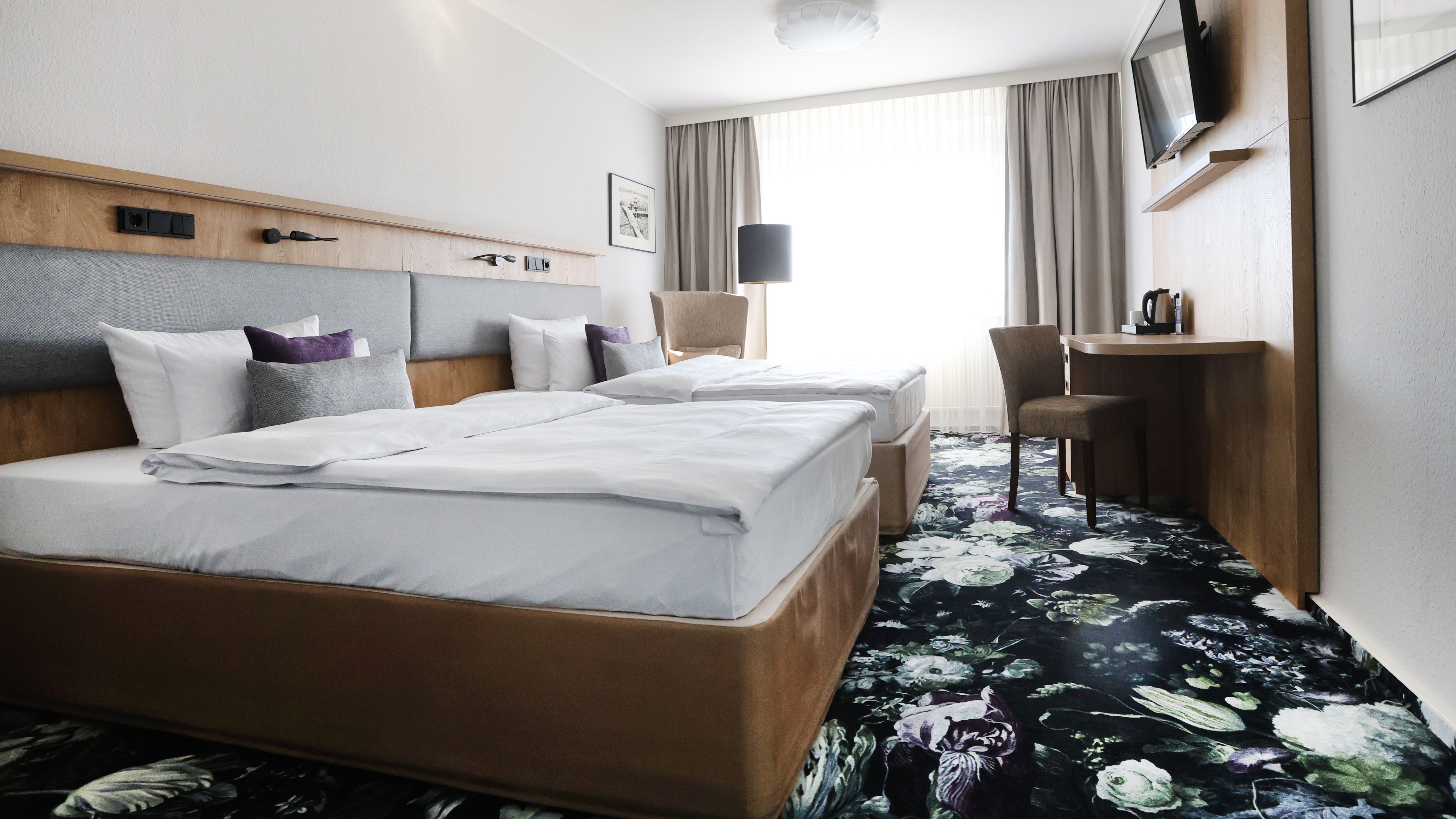 Ein Hotezimmer mit Doppelbett und Fernseher. 