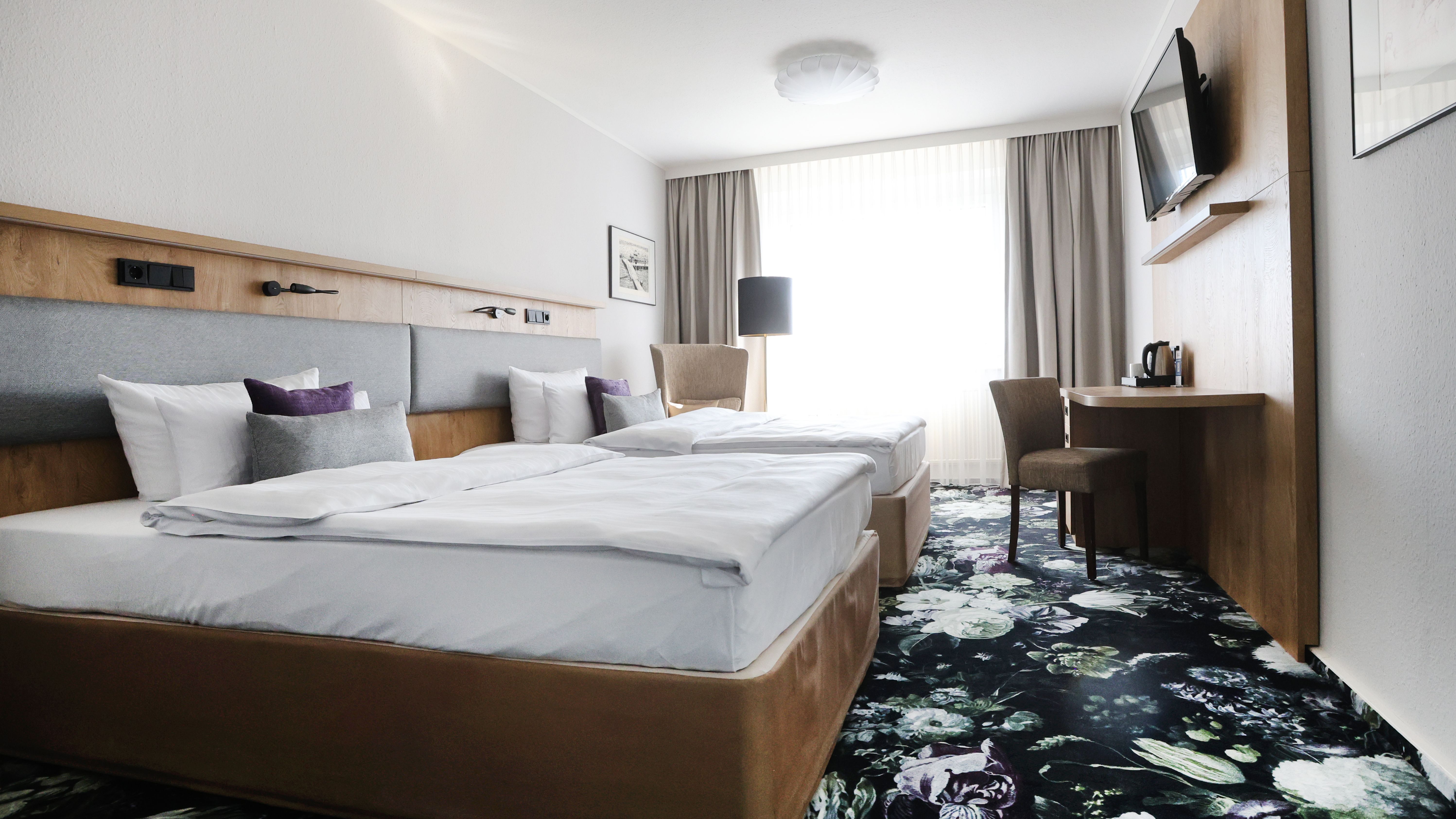 Ein Hotezimmer mit Doppelbett und Fernseher. 