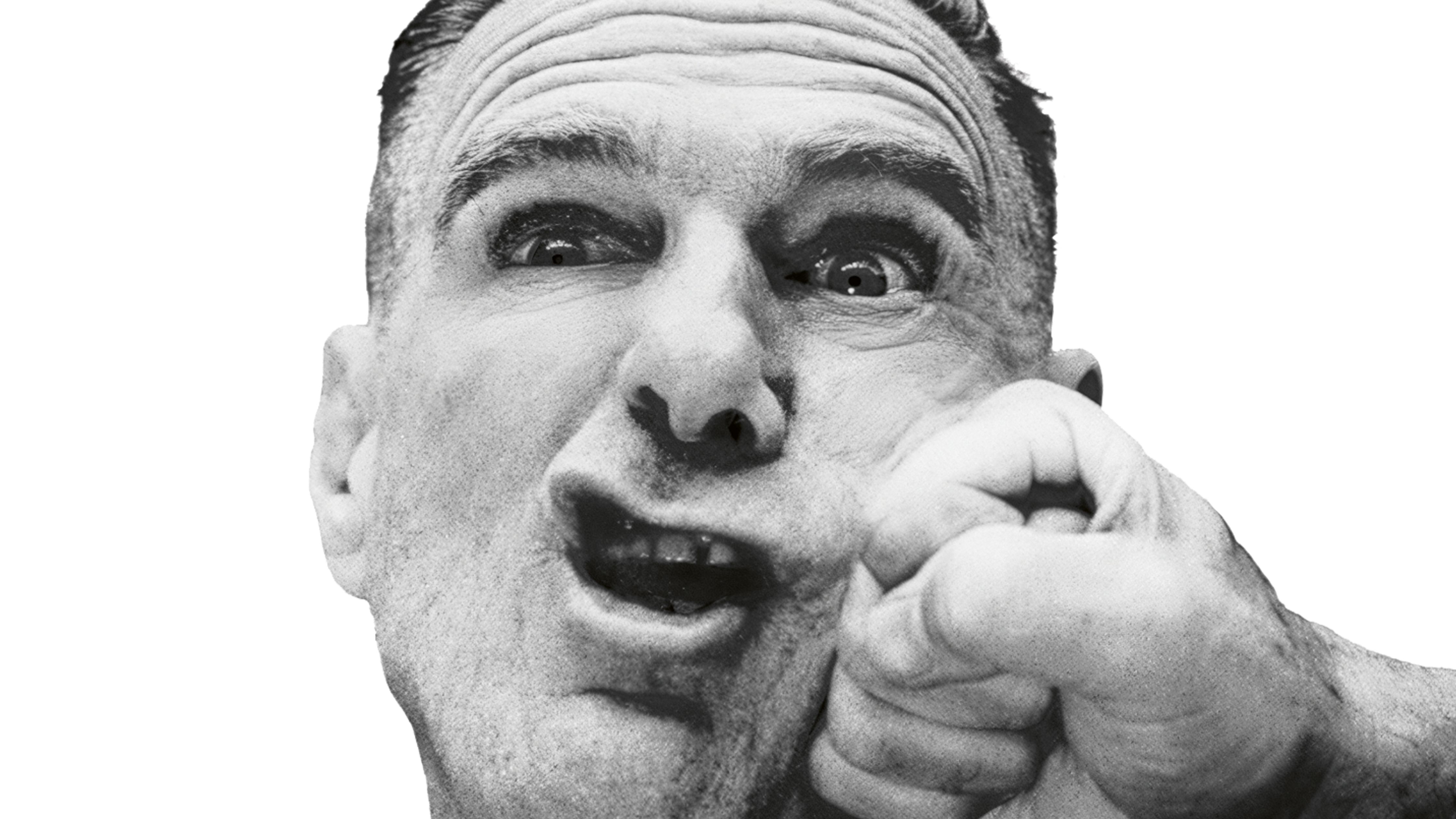 Ein schwarz-weiß Bild von Bryan Adams. Seine Wange wird von einer Faust eingedrückt. Er schaut verwundert, seine Augen sind weit geöffnet.  