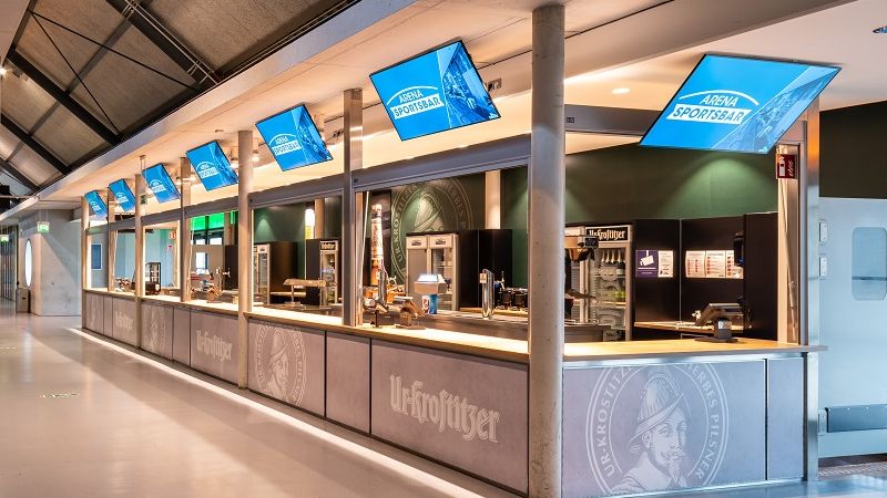 Ein leerer Gastrostand in der ARENA mit angestellten Bildschirmen. 