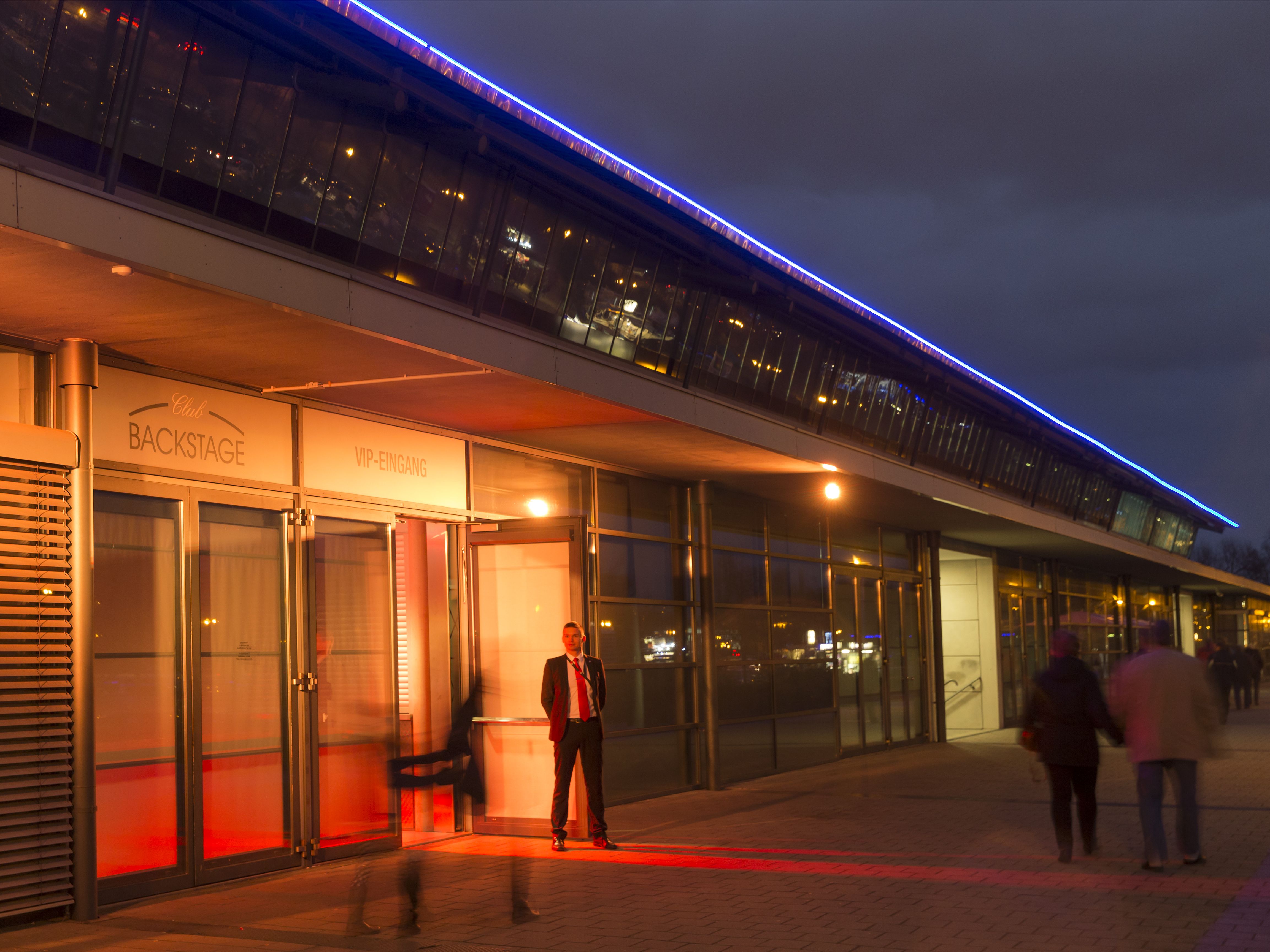 Beleuchteter Eingang des BACKSTAGE CLUB am Abend.