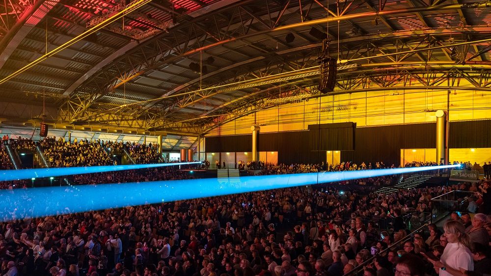 Eine Lichtprojektion verläuft quer durch den Innenraum der ARENA.