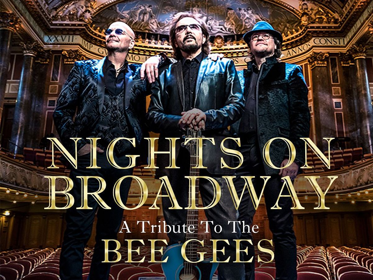 Die Band steht auf der Bühne eines alten Theaters. 