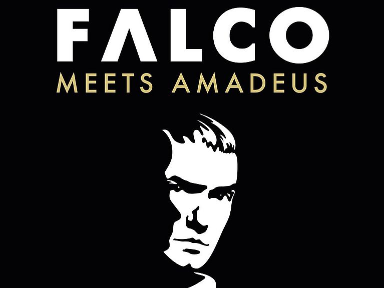 Schwarzes quadratisches Poster der Show Falco Meets Amadeus. In der Mitte ist ein stilisiertes Schwarz-Weiß-Porträt von Falco zu sehen. Nur die rechte Gesichtshälfte und der Kragen seines Anzugs sind weiß hervorgehoben. 