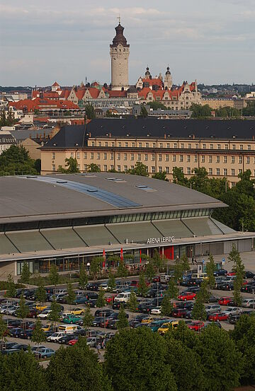 Voller Parkplatz vor der QUARTERBACK Immobilien ARENA mit der Stadt Leipzig im Hintergrund.