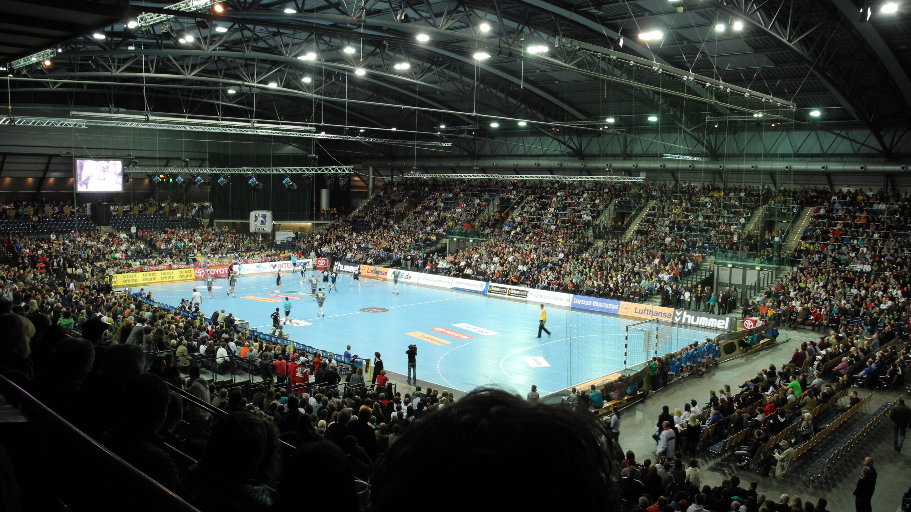 In der QUARTERBACK Immobilien ARENA wird von zahlreichen Zuschauern ein Handballspiel verfolgt.