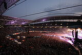 Menschenmasse vor einer beleuchteten Bühne in der Red Bull Arena am Abend.